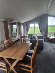 a living room with a wooden table and a couch at Hesket caravan park Plot Number 7 STRICTLY NOT FOR COMMERCIAL USE in High Hesket