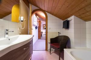 a bathroom with a sink and a bath tub at Landhaus Charivari Sommer-Hörnerbahnen kostenlos in Bolsterlang