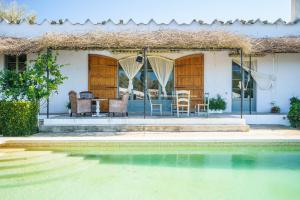 a house with a table and chairs next to a swimming pool at Sa Palmera in Montuiri
