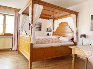 a bedroom with a wooden bed with a canopy at Landhaus Charivari Sommer-Hörnerbahnen kostenlos in Bolsterlang