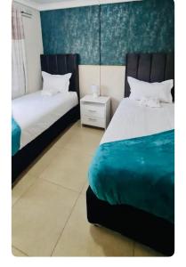 1 dormitorio con 2 camas y mesita de noche en Beautiful 3-Bed House in Harare en Harare