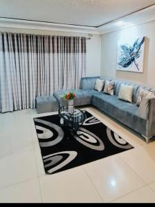 哈拉雷的住宿－Beautiful 3-Bed House in Harare，客厅配有蓝色的沙发和桌子