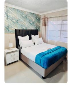 - une chambre avec un lit orné d'une peinture murale dans l'établissement Beautiful 3-Bed House in Harare, à Harare