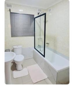 a bathroom with a toilet and a tub and a sink at Emerald Suite 3-Bed House in Harare in Harare