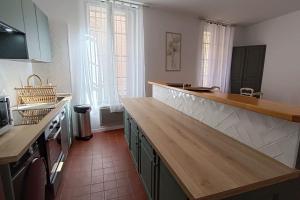 a kitchen with a wooden counter top in a room at hypercentre, appartement coquet en rez-de-chaussée in Perpignan