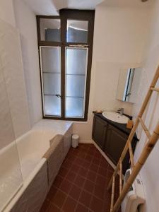 a bathroom with a tub and a sink at hypercentre, appartement coquet en rez-de-chaussée in Perpignan