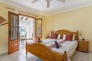 ein Schlafzimmer mit einem großen Holzbett in einem Zimmer in der Unterkunft Villa Piscine à la Fustera Benissa in Benissa + 17 Fotos