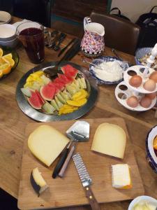 Kockengen的住宿－BoHo Experience Wellness, Jacuzzi, Sauna, BBQ, Garden, Sleeps 10，切板上一张桌子,上面放着奶酪和水果