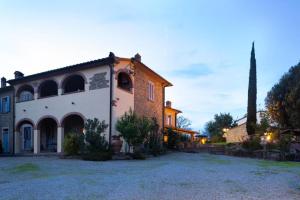 una grande casa con un cortile davanti di Agriturismo Borgo Sant'Ercolano a Ciggiano