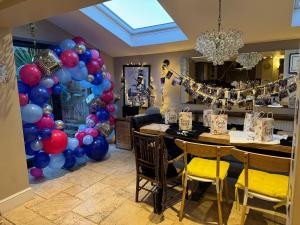 Pokój ze stołem z balonami i żyrandolem w obiekcie Stone Cottage w mieście Norwich