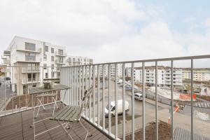 einen Balkon mit einem Tisch, einem Stuhl und Gebäuden in der Unterkunft Bright Pastel Apartment with Desk for Remote Work, Balcony and Parking by Renters in Danzig