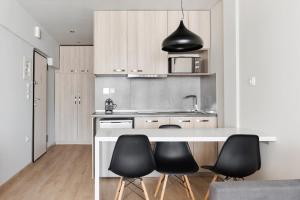 a kitchen with black chairs around a white counter at #Aura Studios & Suites V9-10 in Thessaloniki
