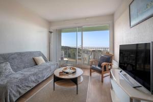 a living room with a couch and a tv at Appartement face mer pour 4 a Saint Brevin L Ocean in Saint-Brevin-les-Pins
