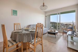 a dining room and living room with a table and chairs at Appartement face mer pour 4 a Saint Brevin L Ocean in Saint-Brevin-les-Pins