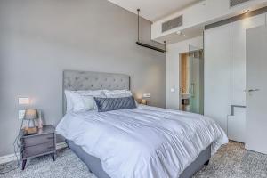 a bedroom with a large bed and a glass door at Luxurious One Bedroom Apartment In Sandton in Johannesburg