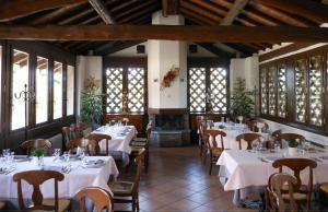 a dining room with tables and chairs and a fireplace at Agriturismo Cassinazza in Orsenigo