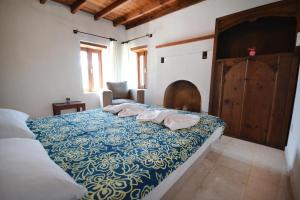 a bedroom with a bed with a blue and white blanket at Kilim Kaya Villas in Kınalı +73 photos