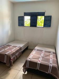 duas camas num quarto com duas janelas em Casa na praia Fagundes/Lucena 