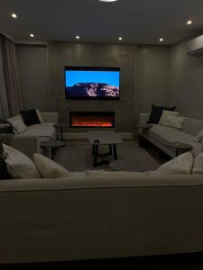 a living room with a fireplace and a flat screen tv at بيت عطلات مفروش بالخبر in Al Khobar
