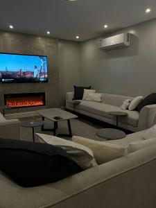 a living room with couches and a fire place at بيت عطلات مفروش بالخبر in Al Khobar