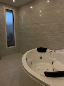 eine weiße Badewanne im Bad mit Fenster in der Unterkunft بيت عطلات مفروش بالخبر in Khobar