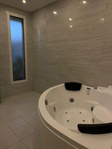 a white bath tub in a bathroom with a window at بيت عطلات مفروش بالخبر in Al Khobar +13 photos
