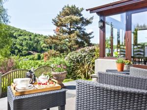 a table and chairs on a patio with a tray of food at Hill Crest Country Guest House in Newby Bridge
