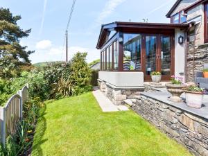 a garden with a stone fence and a house at Hill Crest Country Guest House in Newby Bridge