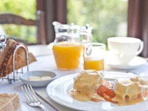 stół z talerzem śniadaniowym i sokiem pomarańczowym w obiekcie Hill Crest Country Guest House w mieście Newby Bridge