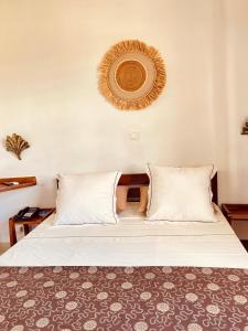 a bedroom with a bed with white pillows at LE NOUVEL EDEN in Toliara