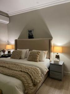 a bedroom with a large bed and two lamps at بيت عطلات مفروش بالخبر in Al Khobar