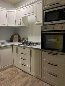 a kitchen with white cabinets and a stove top oven at بيت عطلات مفروش بالخبر in Al Khobar
