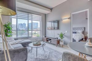 a living room with a couch and a table at Luxurious One Bedroom Apartment In Sandton in Johannesburg