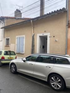 un coche plateado estacionado frente a una casa en Grand STUDIO SUR COUR PRIVATIVE en Muret