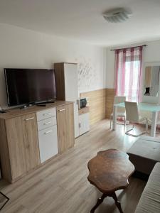 a living room with a flat screen tv and a table at Sweet Dream Guesthouse in Szeged
