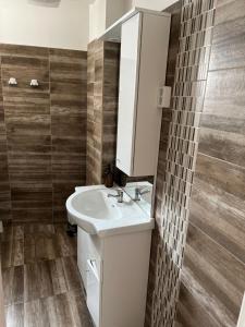 uma casa de banho com um lavatório branco e um espelho. em Sweet Dream Guesthouse em Szeged