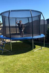 Młody chłopiec stoi na trampolinie. w obiekcie Quiet & Warm House Parking Sleeps 7, 19 mins from CHC airport w mieście Prebbleton