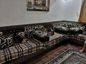 a black and white couch with pillows on it at شاليه ليالي السيب in Seeb