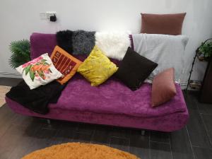a purple couch with many pillows on it at شاليه ليالي السيب in Seeb