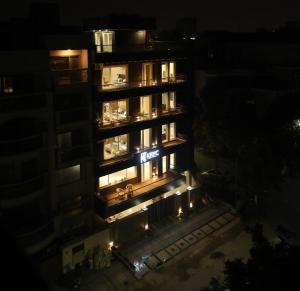 un edificio alto con luces encendidas por la noche en KRYC Luxury Living en Nueva Delhi