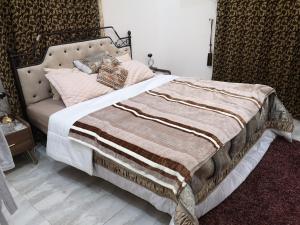 a bed with a blanket and pillows on it at شاليه ليالي السيب in Seeb