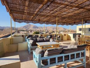 a patio with couches and tables and a view of the desert at Royal Mountain in Luxor