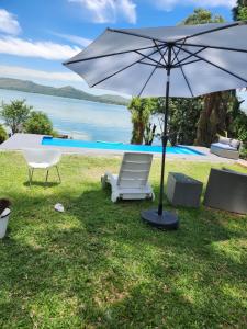 a chair and an umbrella next to a pool at Le Bamboo Guest House And Boat Cruise in Hartbeespoort