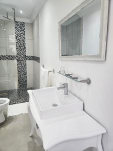 a white bathroom with a sink and a shower at Le Bamboo Guest House And Boat Cruise in Hartbeespoort