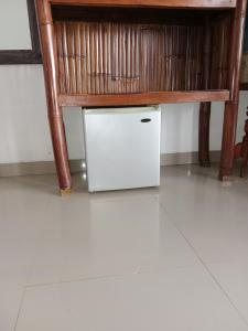 a small white refrigerator under a wooden bench at Kumpul Beach in Amed