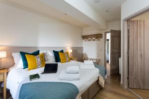 a bedroom with a large bed with a laptop on it at The Barn at Plas Ashpool Sleeps 8 in Llandyrnog