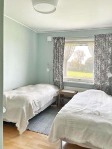 1 Schlafzimmer mit 2 Betten und einem Fenster in der Unterkunft Country house with sea view near Hovs Hallar in Båstad