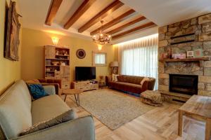 a living room with a couch and a stone fireplace at Captivating 3-Bed Villa in Brezovica Ski Centre in Brezovica
