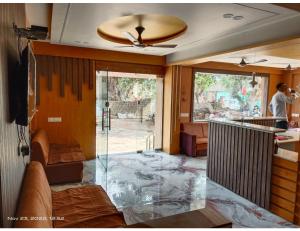 a living room with a glass floor and a ceiling at Hotel Shiv Sadan, Somnath in Somnath