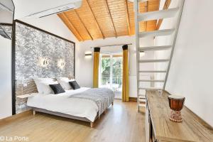1 dormitorio con 1 cama y escalera de caracol en DOMAINE DE LA PORTE en Agonac
